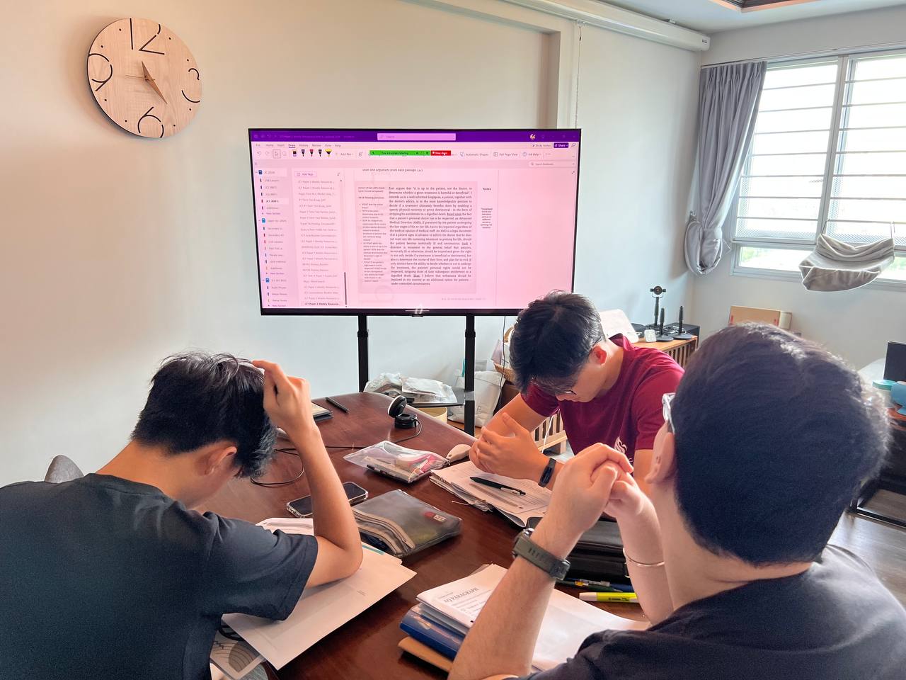 Three students studying together around a table.