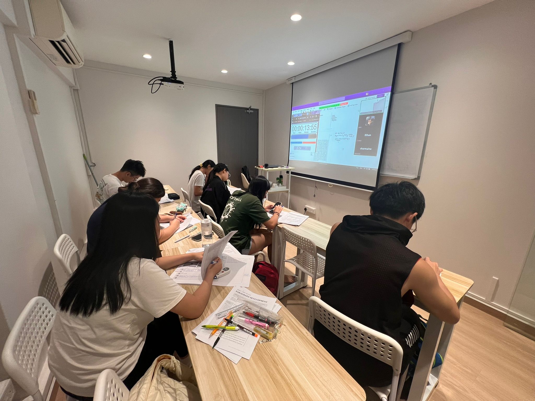Students working in a classroom with a projector.