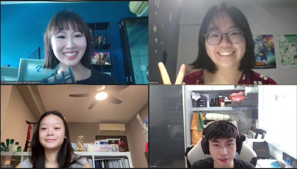 Four people smiling during an online video call.
