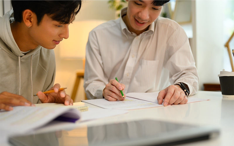 Two people studying together at table.
