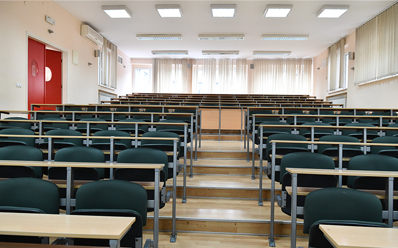 Empty lecture hall with tiered seating.